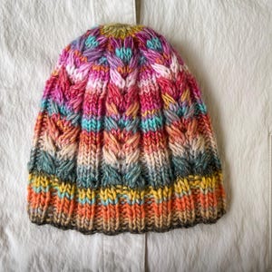 Women&#39;s hat knitted from high-quality wool. Hand-knitted multicolored wool hat. Knitted hat with colorful stripes. Warm hat handmade.