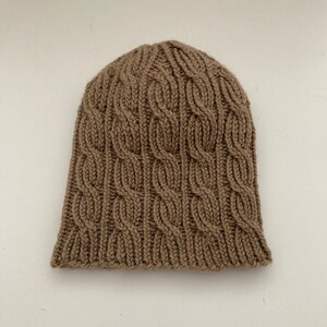 Women&#39;s beanie hand-knitted camel. Wool hat ladies in braid pattern. Knitted cap self-knitted merino wool. Women&#39;s hat knitted autumn winter