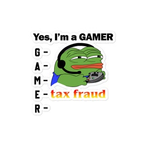 May include: A green cartoon frog wearing a headset and holding a video game controller. The text "Yes, I'm a GAMER" is above the frog. The letters G, A, M, E, and R are listed vertically with a dash next to each letter. The word "tax fraud" is written next to the letter E.