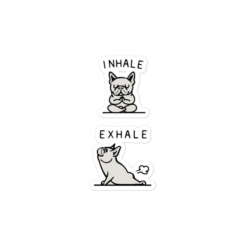 Op de afbeelding: Twee stickers met een zwart-witte illustratie van een Franse bulldog. De bovenste sticker zegt "INHALE" en toont de hond zittend in een yogapose. De onderste sticker zegt "EXHALE" en toont de hond in een neerwaartse hondpose.