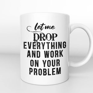 Könnte beinhalten: Weiße Keramik-Kaffeetasse mit schwarzem Text, der "Lass mich alles fallen lassen und an deinem Problem arbeiten." lautet.