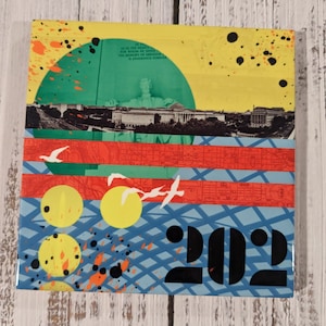 May include: A colorful abstract collage featuring a cityscape, red and blue stripes, yellow circles, and the number 202. The text "As in the hearts for whom he saved the memory of a nation is enshrined forever" is visible in the background.