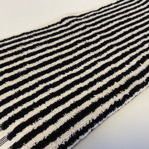 May include: Black and white striped kitchen towel. The towel is made of a soft, absorbent material and is perfect for drying dishes, hands, and spills.