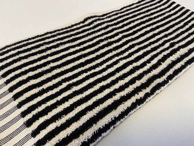 May include: Black and white striped kitchen towel. The towel is made of a soft, absorbent material and is perfect for drying dishes, hands, and spills.