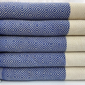 Peut inclure: Une pile de cinq serviettes turques à franges, à motifs bleus et blancs. Les serviettes sont pliées en deux et empilées les unes sur les autres.