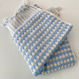May include: Two blue and white striped towels with a waffle texture. One towel has a blue and white checkered pattern and the other has a blue and white striped pattern.