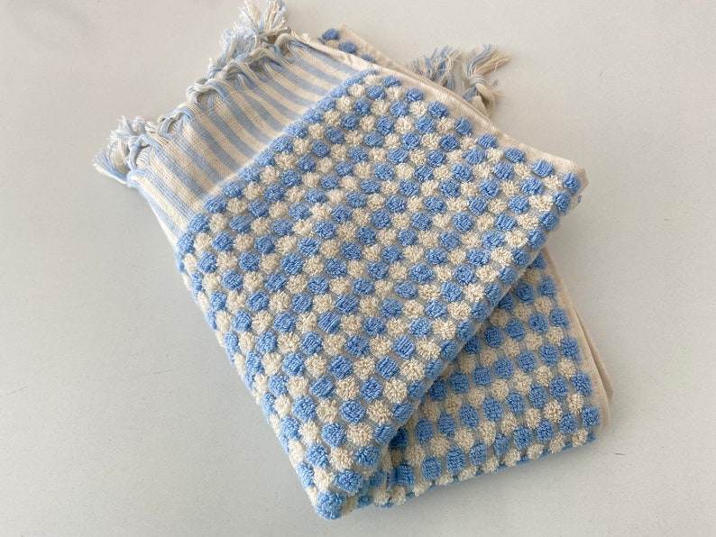 May include: Two blue and white striped towels with a waffle texture. One towel has a blue and white checkered pattern and the other has a blue and white striped pattern.