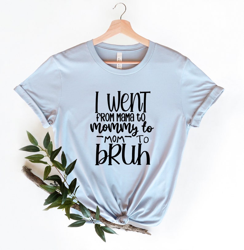 May include: Light blue t-shirt with black text that reads "I went from mama to mommy to -mom- to bruh".