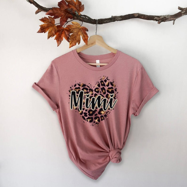 May include: A dusty rose t-shirt with a leopard print heart design and the word "Mimi" in black text.