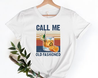 May include: White t-shirt with a vintage-style graphic of an old fashioned cocktail with the text "Call me Old Fashioned".