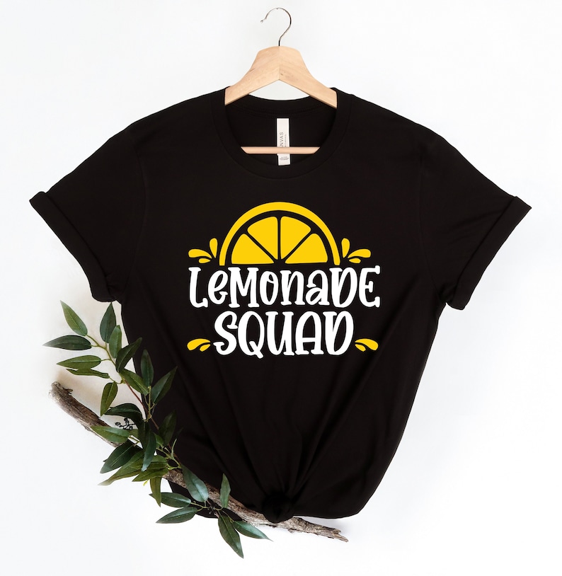 May include: Black t-shirt with a white graphic of a yellow lemon slice and the text "Lemonade Squad".