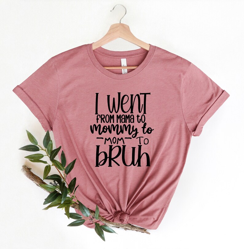 May include: A mauve t-shirt with the text "I went from mama to mommy to -mom- to bruh" printed in black.