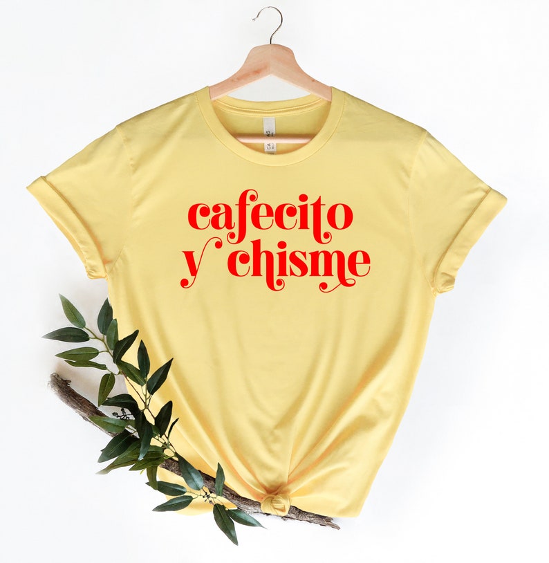 May include: Yellow t-shirt with the text "cafecito y chisme" in red.