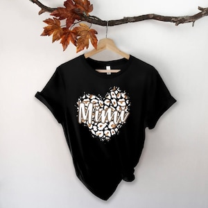May include: Black t-shirt with a leopard print heart design and the word "Mimi" in white text.