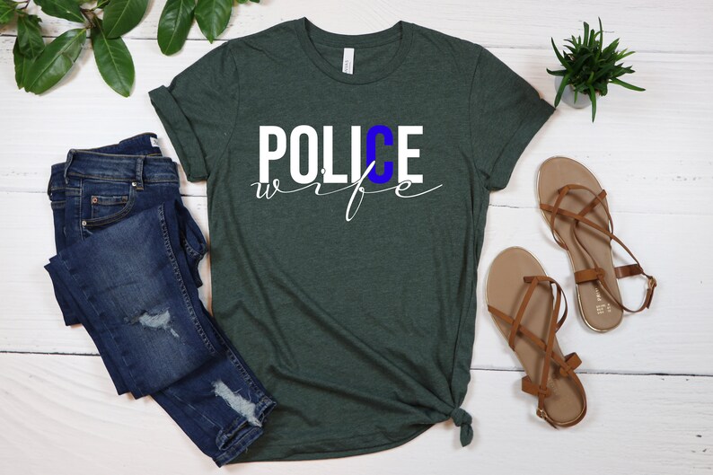 May include: A green t-shirt with the words "POLICE wife" in white lettering. The "C" in "POLICE" is blue.