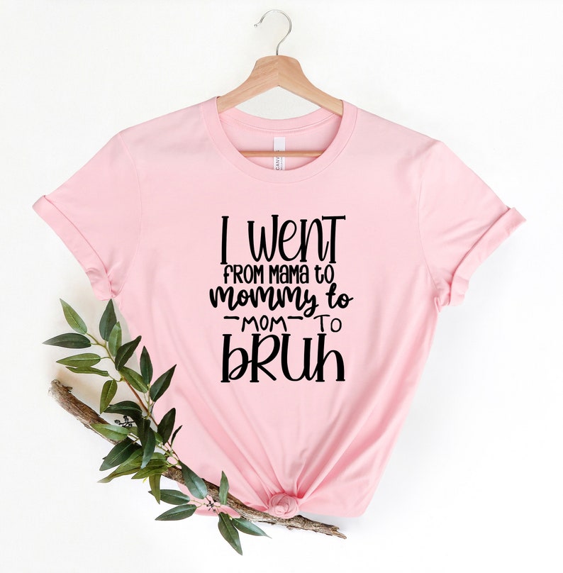 May include: Pink t-shirt with black text that reads "I went from mama to mommy to -mom- to bruh".