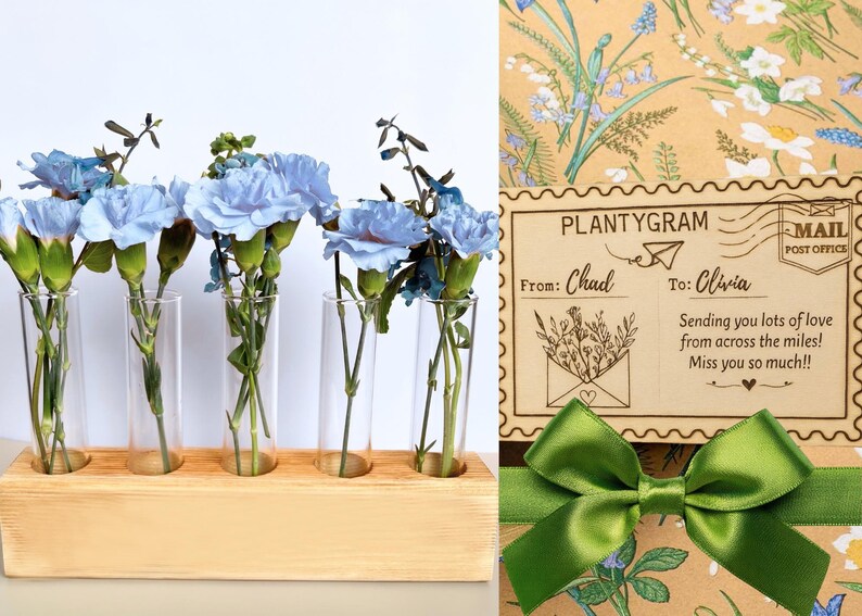 May include: A floral arrangement featuring blue carnations in glass tubes set in a wooden holder. A card with the text "PLANTYGRAM" and a green ribbon are also visible. The card reads "From: Chad To: Olivia".