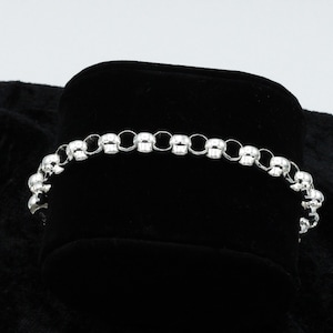 May include: A silver bracelet with a chain made of small, round beads.