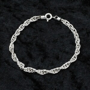 May include: A silver rope chain bracelet with a lobster clasp fastening.