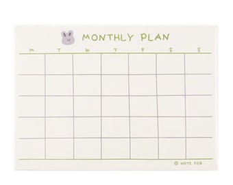 May include: A white monthly planner with a light purple bunny illustration at the top. The planner has a grid layout with the days of the week labeled: M, T, W, T, F, S, S. The bottom right corner has the text "NOTE FOR".