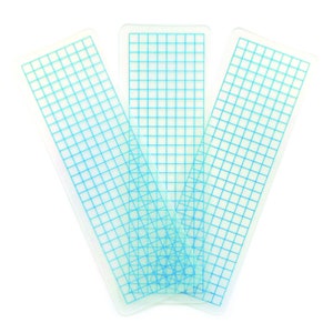 May include: Three clear plastic rulers with blue grid lines. The rulers are stacked on top of each other.