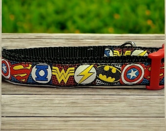 May include: A black dog collar with a red buckle and a colorful superhero themed print featuring Superman, Wonder Woman, Batman, The Flash, and Captain America logos.