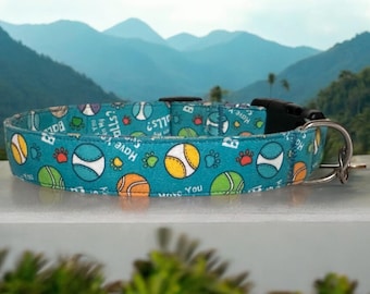 May include: A turquoise blue dog collar with a repeating pattern of tennis balls, paw prints, and the text "I love you" and "Balls are my jam".