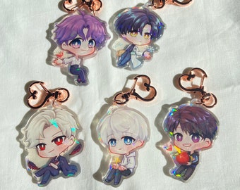 Può includere: Cinque portachiavi iridescenti con personaggi in stile anime. Ogni portachiavi ha un anello metallico a forma di cuore e un ciondolo in acrilico trasparente con un personaggio diverso. I personaggi sono tutti maschi e hanno colori e stili di capelli diversi.