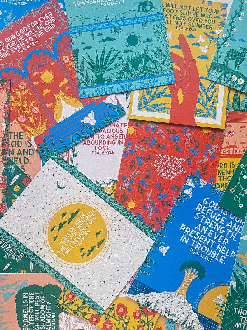 May include: A collection of colorful cards with inspirational quotes and bible verses. The cards feature a variety of illustrations, including flowers, trees, and hands. The text on the cards includes phrases like "God is our refuge and strength" and "The Lord is my shepherd, I shall not want."