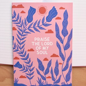 Può includere: Un quaderno rosa con un design floreale e il testo "Loda il Signore della mia anima".
