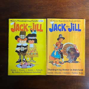 May include: Two vintage Jack and Jill magazines from November 1965. The cover of the left magazine features a Pilgrim girl and boy roasting marshmallows over a fire. The cover of the right magazine features a Pilgrim girl and boy holding a turkey. The text on the left magazine reads "Macy's Thanksgiving Parade in Color" and "Stories * Puzzles * Games * Cutouts". The text on the right magazine reads "The Better Magazine for Boys and Girls" and "Thanksgiving Dinner in Storyland".