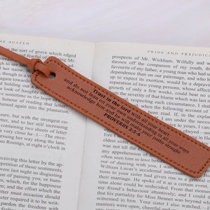 May include: A brown leather bookmark with a gold embossed quote from Proverbs 3:5-6: "Trust in the Lord with all your heart and do not lean on your own understanding; in all your ways acknowledge him, and he will make your paths straight."