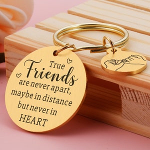 Puede incluir: Llavero dorado con un dije redondo que dice "True Friends are never apart, maybe in distance but never in HEART". Un dije más pequeño con dos manos entrelazadas está unido al llavero.