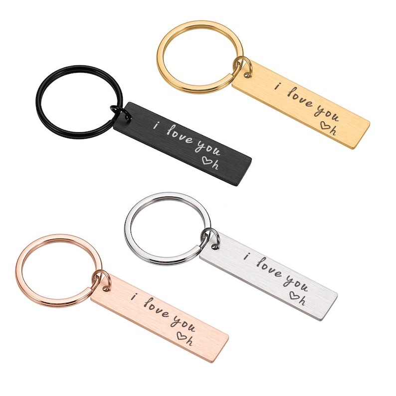 May include: Four keychains with different colored metal rings and rectangular tags that say "i love you" with a heart symbol.