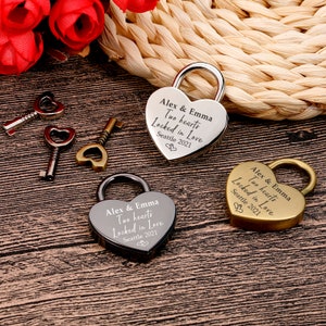 May include: Three heart-shaped padlocks with keys, each engraved with "Alex & Emma Two hearts Locked in Love Seattle 2021". One padlock is silver, one is gold, and one is black.