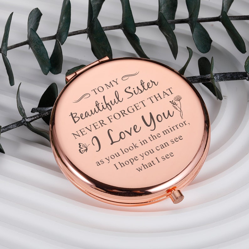 May include: A rose gold compact mirror with an engraved message: "To my beautiful sister, never forget that I love you, as you look in the mirror, I hope you can see what I see."