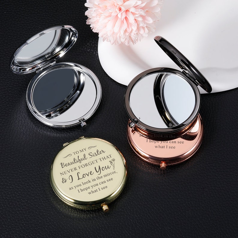 May include: Three compact mirrors with different colored frames: silver, black, and gold. The gold mirror has an engraved message: "To my Beautiful Sister Never Forget That I Love You as you look in the mirror, I hope you can see what I see."
