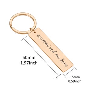 May include: Gold-toned metal keychain with a rectangular tag that reads "customized me here". The tag is 50mm long and 15mm wide.