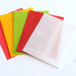 May include: A collection of colorful tissue paper sheets in red, yellow, green, and white. The sheets are arranged in a fan-like pattern, with the white sheets in the foreground. The tissue paper is likely used for gift wrapping or crafting.