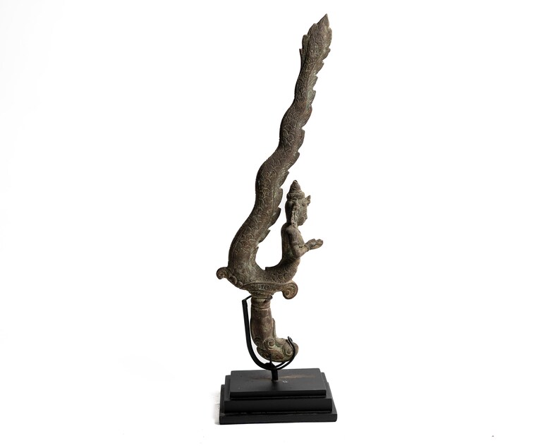 May include: A bronze sculpture of a mythical creature with a human-like torso and a serpent-like tail. The sculpture is mounted on a black stand.