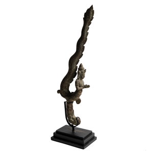 May include: A bronze sculpture of a mythical creature with a human-like figure and a long, feathered tail. The sculpture is mounted on a black wooden base.