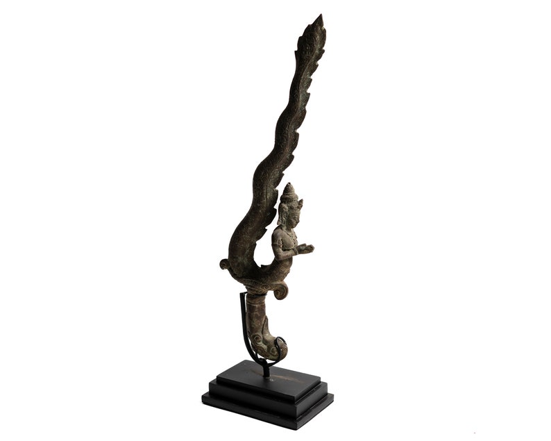 May include: A bronze sculpture of a mythical creature with a human-like figure and a long, feathered tail. The sculpture is mounted on a black wooden base.