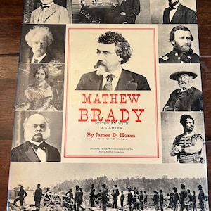 May include: A book cover with a portrait of Mathew Brady, a historian with a camera. The cover features a black and white photo of Brady and a caption that reads "Mathew Brady, Historian with a Camera, by James D. Horan, author of Confederate Agent. Including Exclusive Photographs from the Brady-Handy Collection."