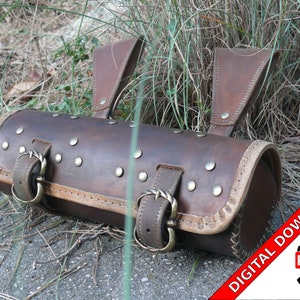 Puede incluir: Alforja de cuero marrón con hebillas y tachuelas metálicas. La bolsa tiene una parte superior enrollada y dos correas. DESCARGA DIGITAL PDF.