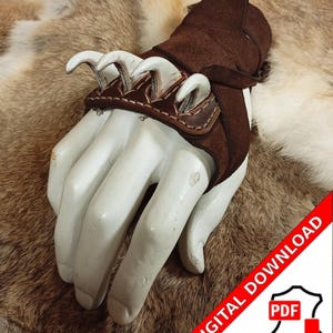 May include: A brown leather gauntlet featuring three white claw-shaped elements. The gauntlet is displayed on a mannequin hand. The image includes a "DIGITAL DOWNLOAD" watermark.