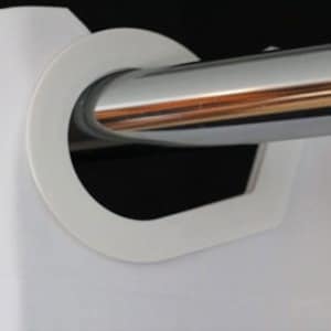 May include: Close-up of a white plastic curtain ring encircling a shiny, silver metal rod. The ring has a rounded shape with a flat back and a curved front, designed to hold a curtain panel. The background is dark.