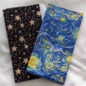 May include: Two rectangular fabric items. One is black with gold stars and swirls. The other features a print of Van Gogh's "Starry Night" painting, with blue, yellow, and white brushstrokes. Both items have a finished edge.