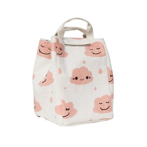 May include: A white canvas lunch bag with a pink cloud pattern. The clouds have smiling faces and are surrounded by small raindrops. The bag has a single top handle.