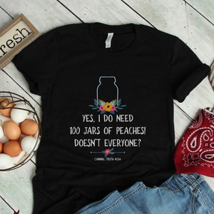 May include: Black t-shirt with a white graphic of a mason jar with flowers and the text "YES, I DO NEED 100 JARS OF PEACHES! DOESN'T EVERYONE? CANNING TRUTH #244"