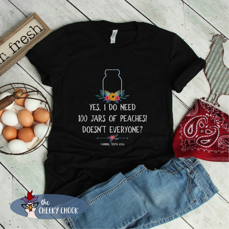 May include: Black t-shirt with a white graphic of a mason jar with flowers and the text "YES, I DO NEED 100 JARS OF PEACHES! DOESN'T EVERYONE? CANNING TRUTH #244"